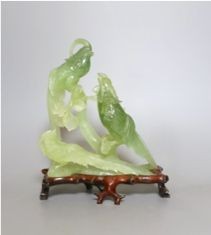 A Chinese bowenite jade bird group on wooden base - 23cm tall